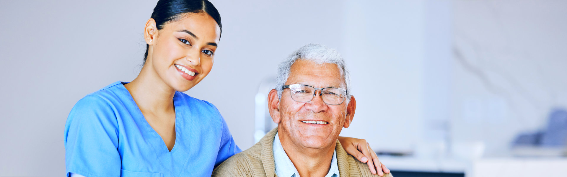 Female caregiver and elderly man smiling